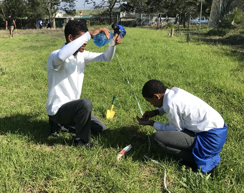 Learners participating in the Iimbovane Outreach Project planting pitfalls to collect ant species for scientific research.