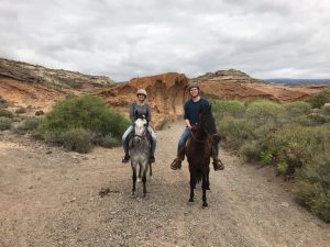 Francois and freind riding horses in a desert
