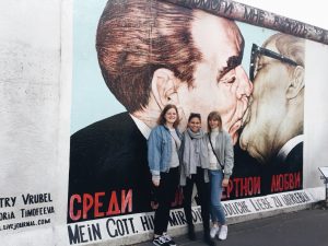 Elizabeth and friends standing behind street art in Berlin